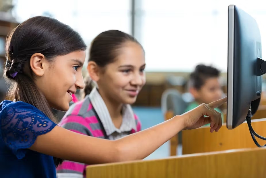 Young students working at a library computer