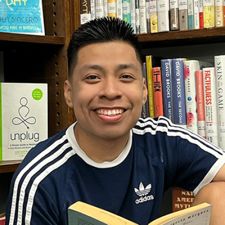 Eddie Bautista Garcia reading in a library