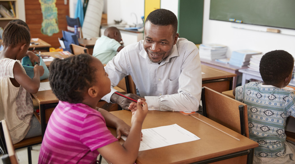 teacher helping elementary student