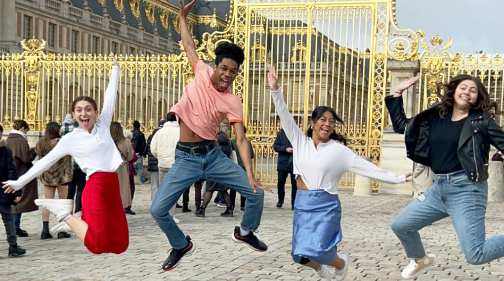 Ohio State students jumping in celebration in front of a golden gate in France