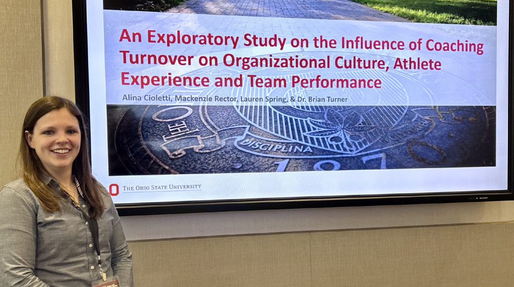 Ohio State graduate student standing next to presentation