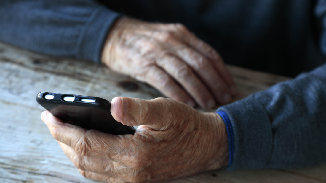 old hands holding smartphone