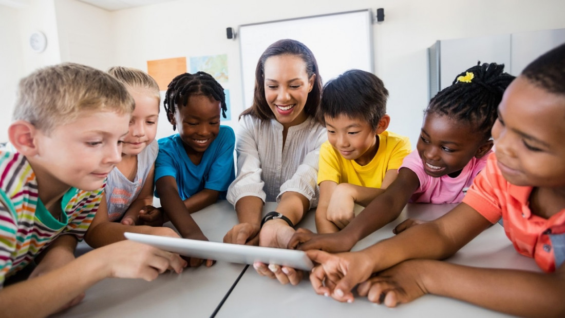 teacher and students looking at tablet