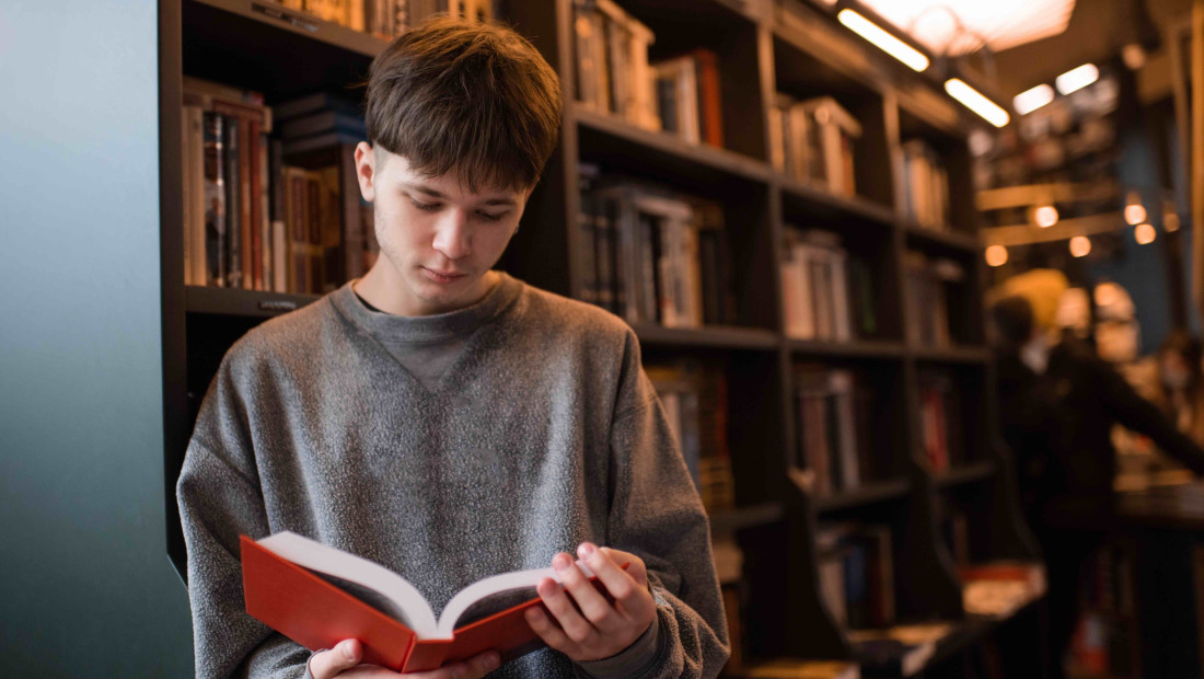 student reading a book in the library