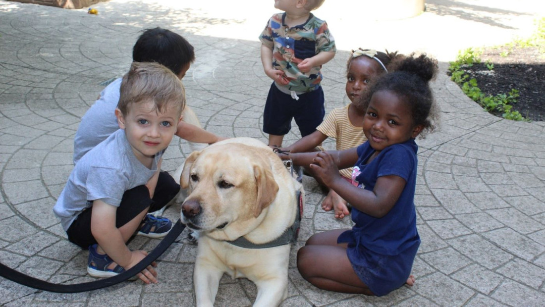 Dog being pet by young students during a Buckeye Paws event