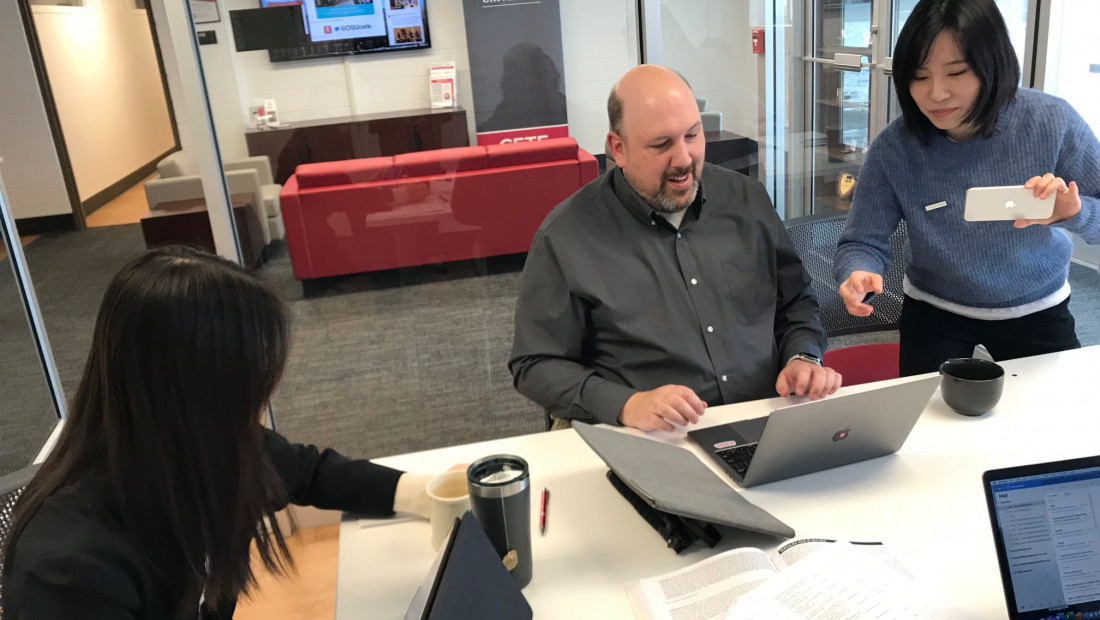 Ohio State office workers at a table with laptops