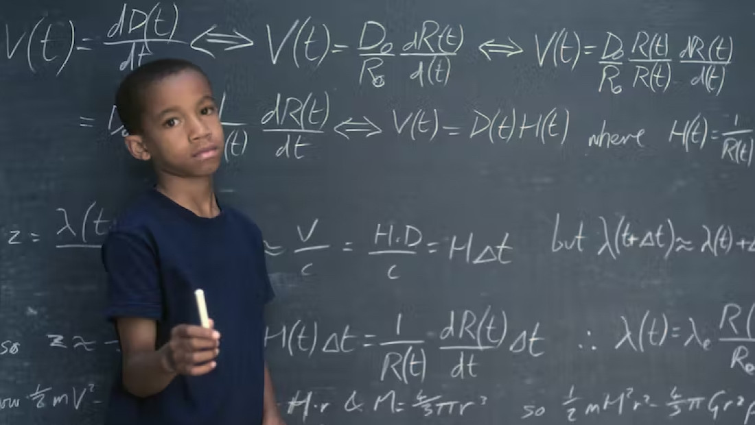 Young student in front of chalkboard with equations