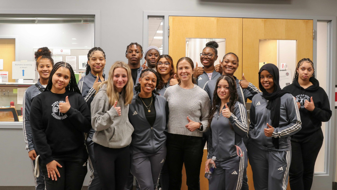 Ohio State exercise science students and professor giving thumbs up in front of lab door