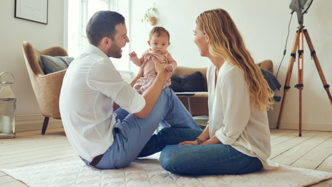 father and mother playing with baby
