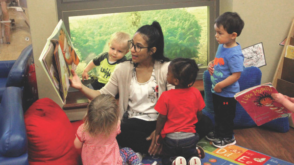 Teacher reading a picture book to young students in a classroom