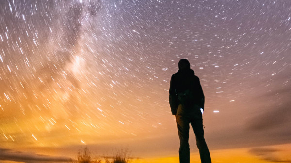 hiker silhouetted against the starry night sky