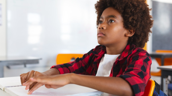 blind schoolboy sitting at desk