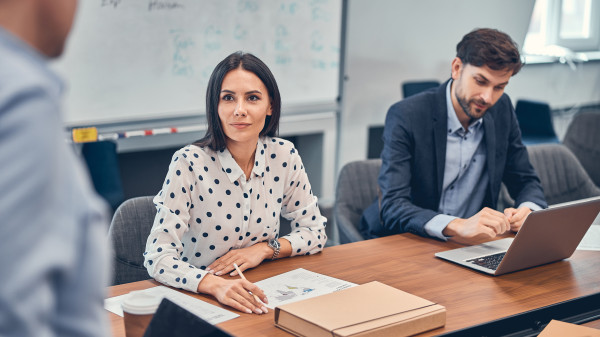 colleagues in office, discussing ideas around table