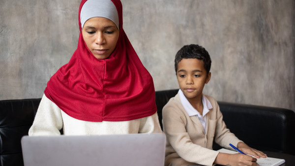 woman helping child with homework