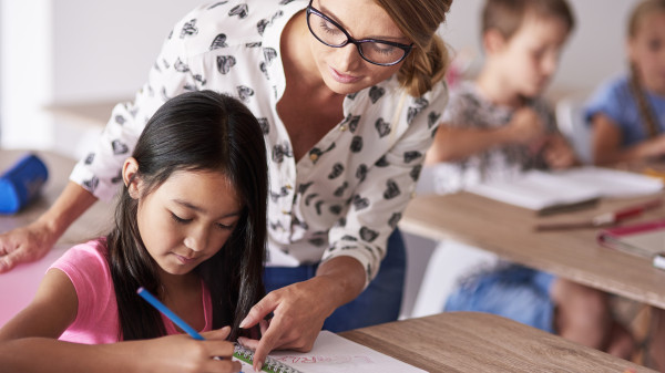 teacher helping young girl