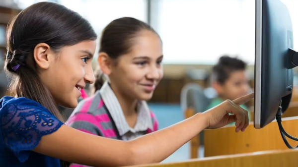 Young students working at a library computer