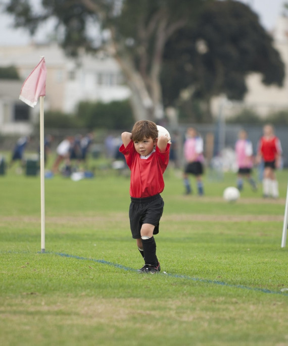 small child playing soccer on a field