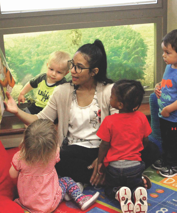 Teacher reading a picture book to young students in a classroom