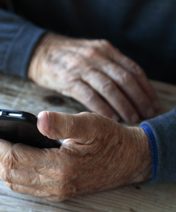 old hands holding smartphone