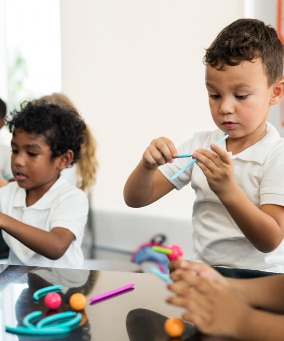 children in kindergarten classroom doing crafts