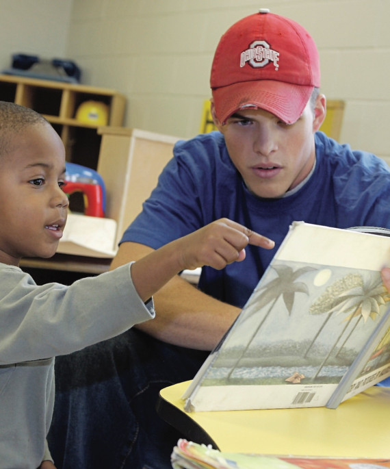 Ohio State student reading picture book to young student