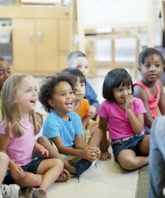 a group of children sitting on the floor in a classroom