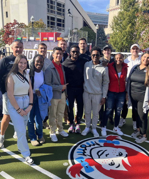 Ohio State Sport Management group posing together for a photo on a football field