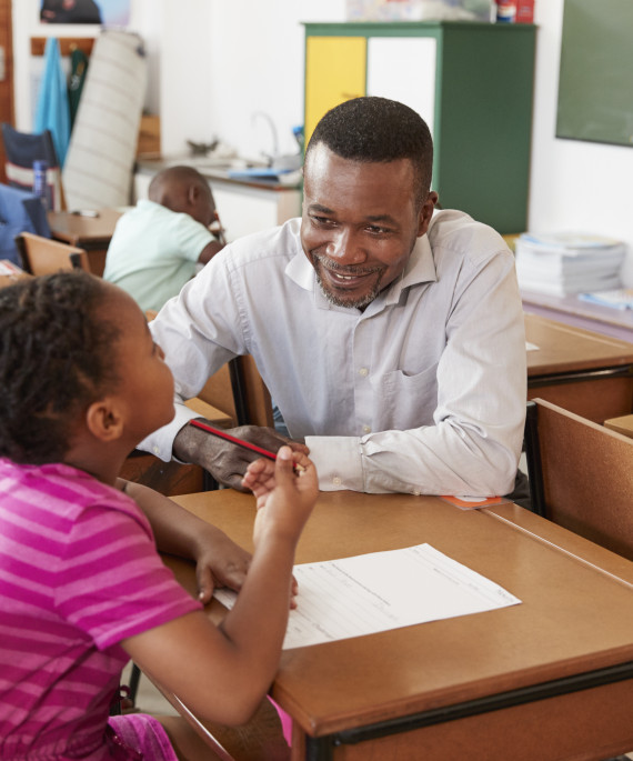 teacher helping elementary student