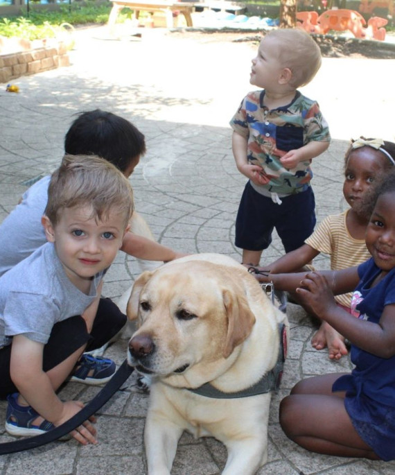 Dog being pet by young students during a Buckeye Paws event