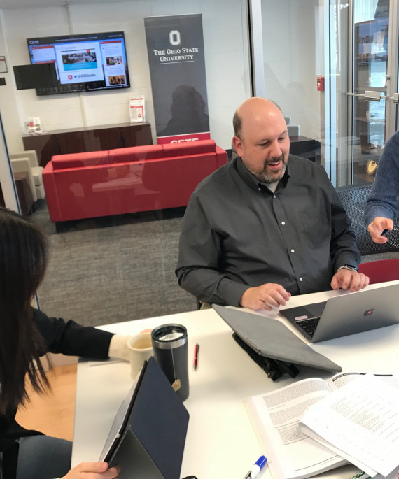Ohio State office workers at a table with laptops