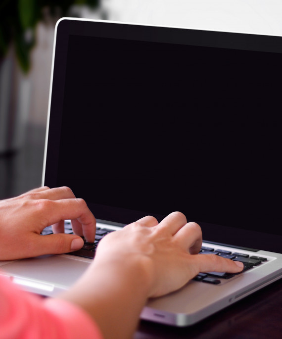 Hands typing on laptop