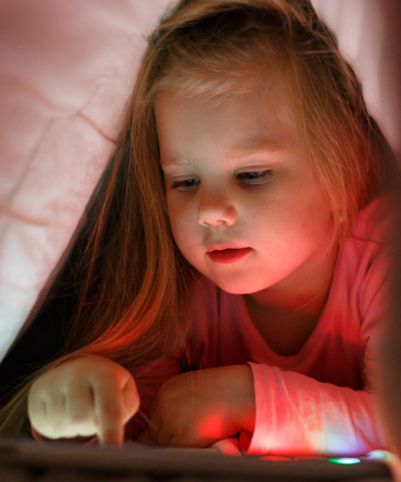 child reading under blanket