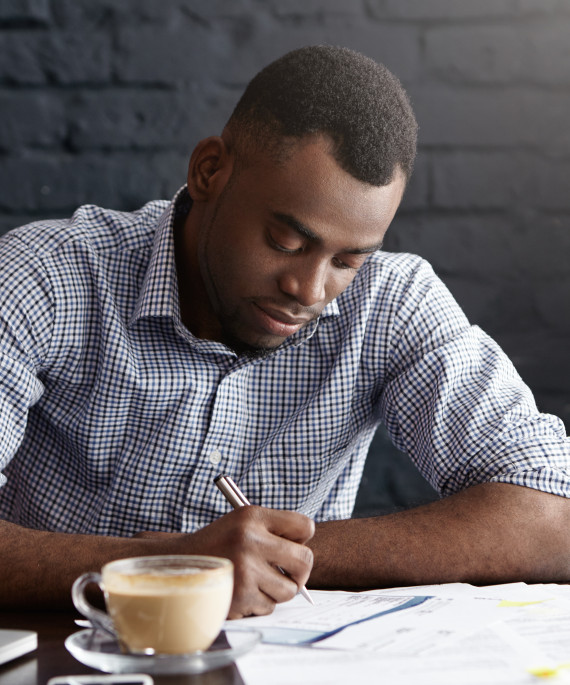 hardworking-young-african-office-worker-handwritin