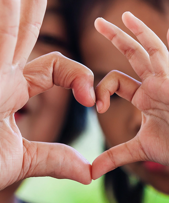Children making a heart shape with their hands