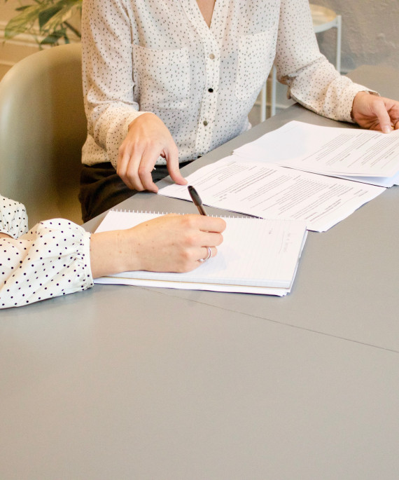 two woman discussing documents