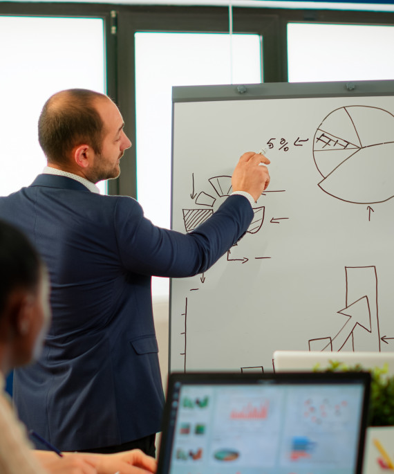 a man standing in front of a white board