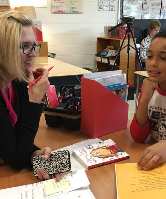 a teacher sitting at a table with a child