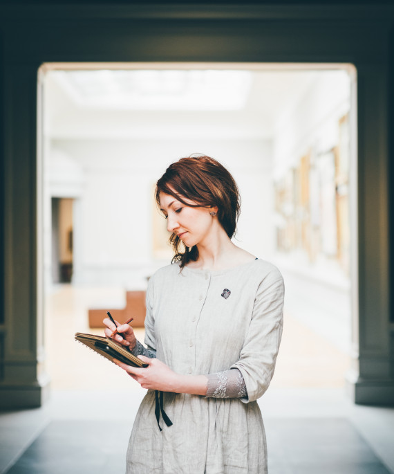 young woman sketching in museum