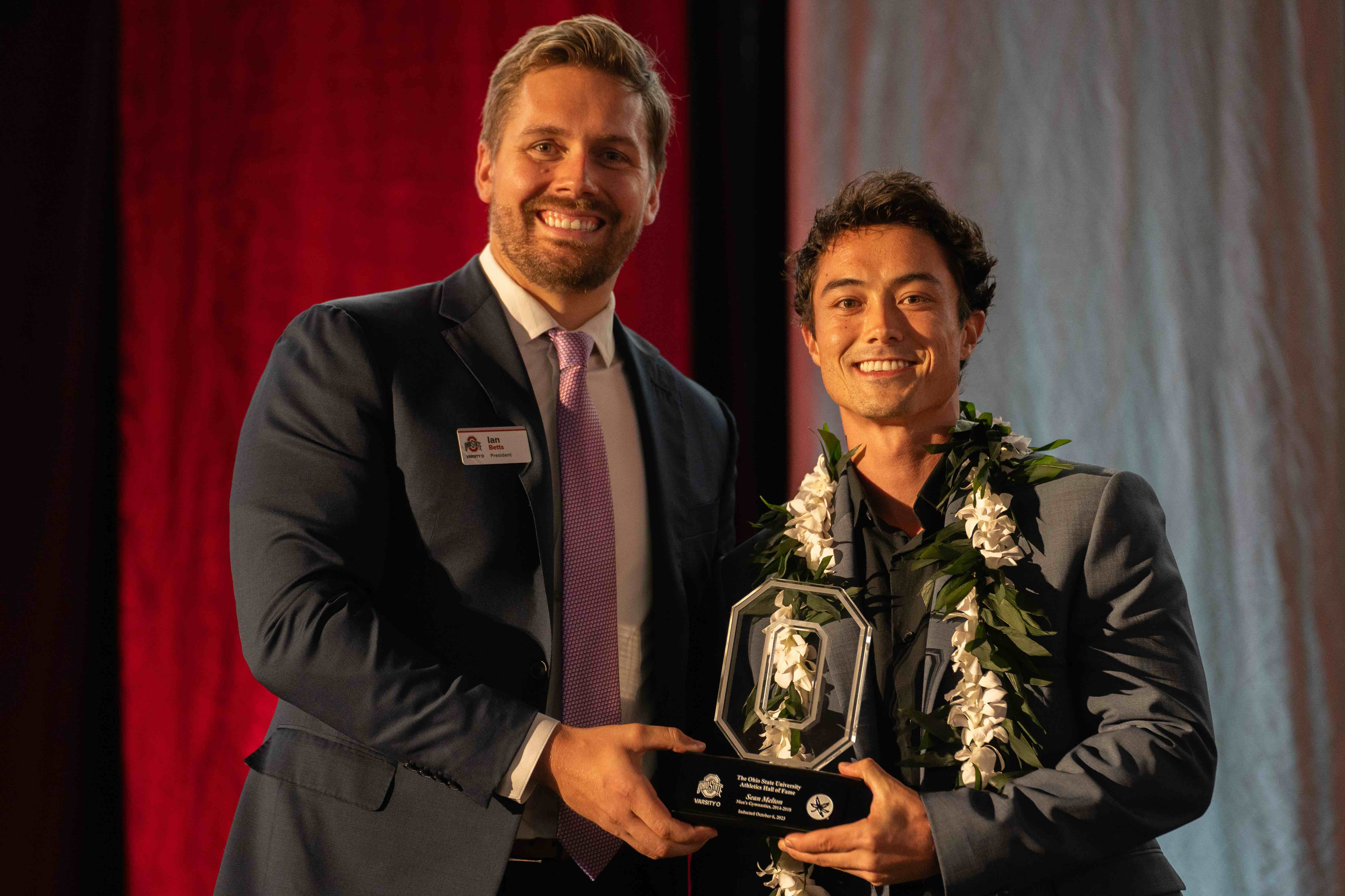 Sean Melton wearing a lei receiving an award from Ohio State 