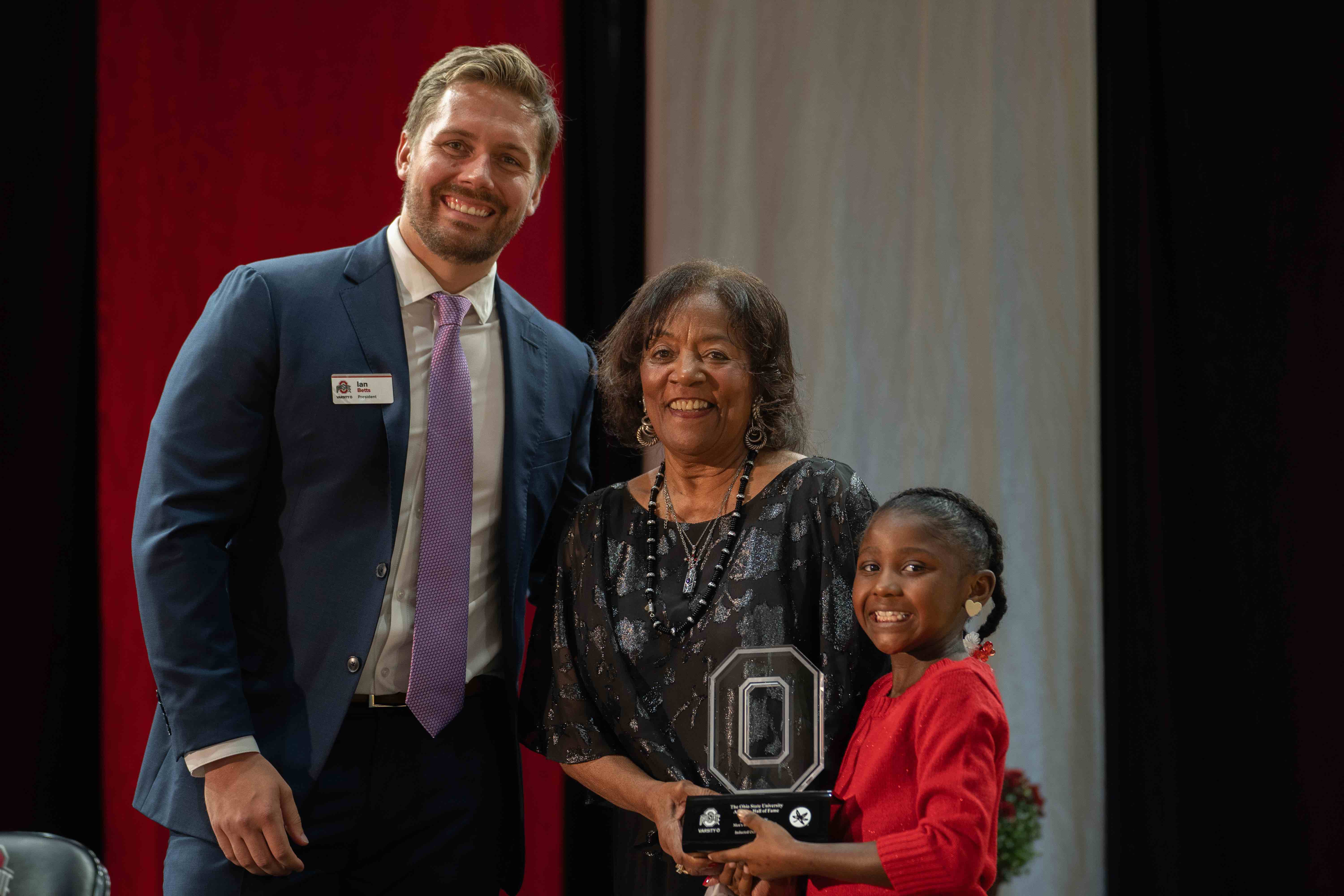 Celia Roberts accepting an award during Ohio State athletic Hall of Fame banquet with a young family member